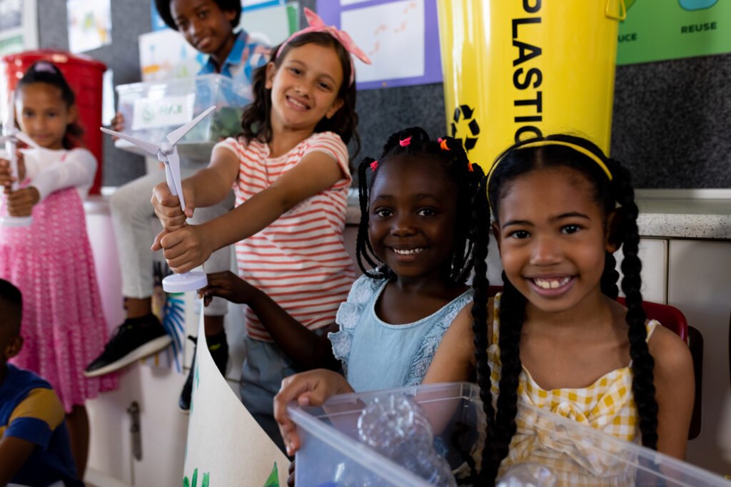Portrait of happy diverse children with ecology items and plants in class at elementary school. School, learning, childhood, ecology, recycling and education, unaltered. Portrait of happy diverse children with ecology items and plants in class at elementary school. School, learning, childhood, ecology, recycling and education, unaltered.